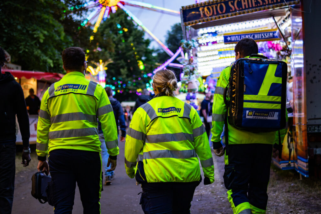 Drei Einsatzkräfte der Veritas Ambulanz im Sanitätsdienst auf einem Volksfest