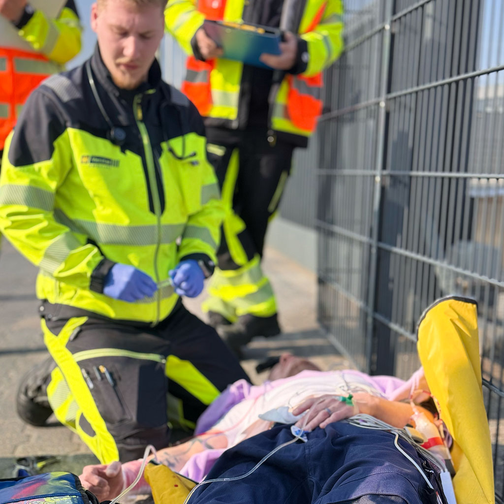 Einsatzkraft betreut eine Patientin auf der Trage während einer Einsatzübung