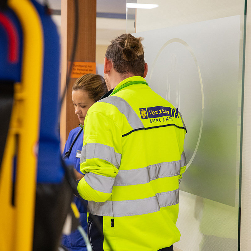 Rettungssanitäter der Veritas Ambulanz bei der Patientenübergabe im Krankenhaus