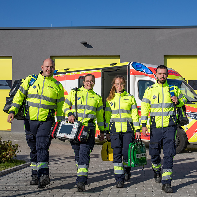 Team der Veritas Ambulanz mit Notfallausrüstung vor dem Rettungswagen